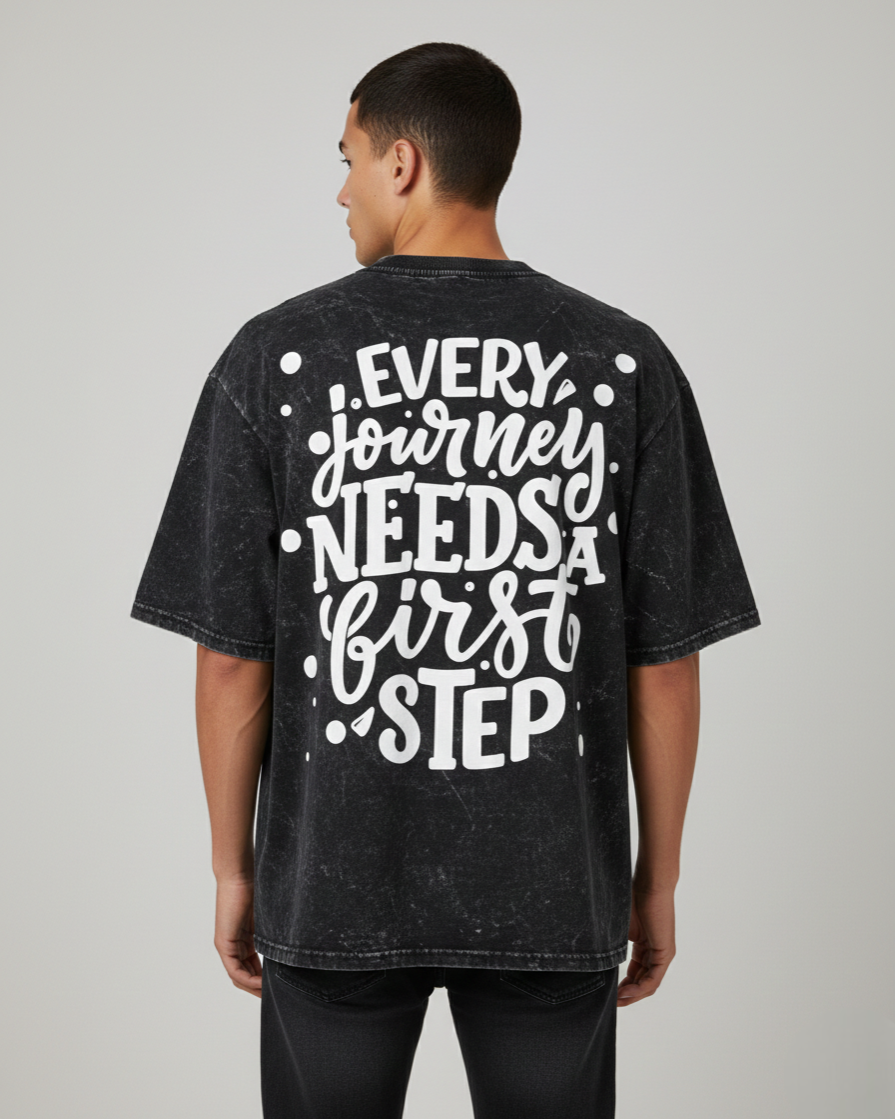 Person wearing a black t-shirt with motivational quote on the back against a plain background