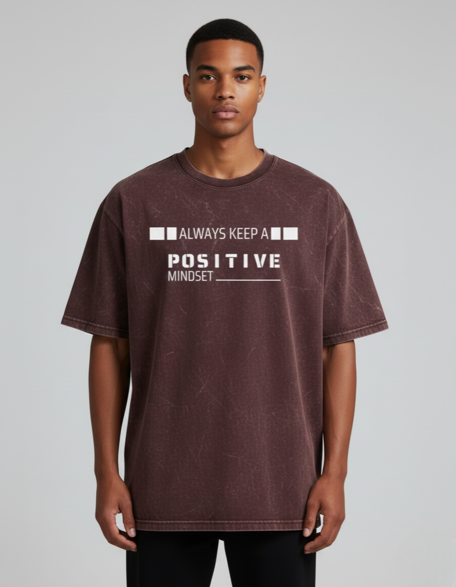 Man wearing a t-shirt with 'Always Keep a Positive Mindset' text on a plain background