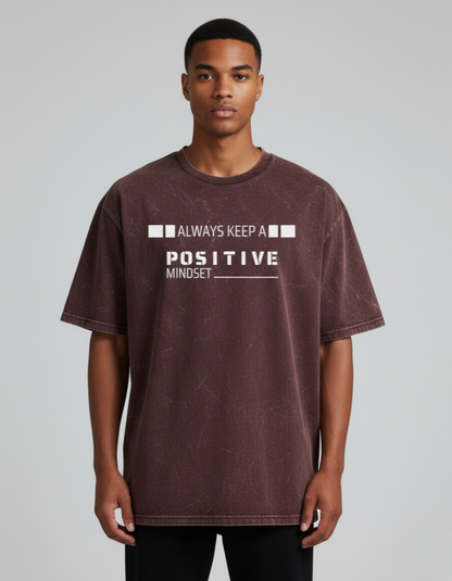 Man wearing a t-shirt with 'Always Keep a Positive Mindset' text on a plain background