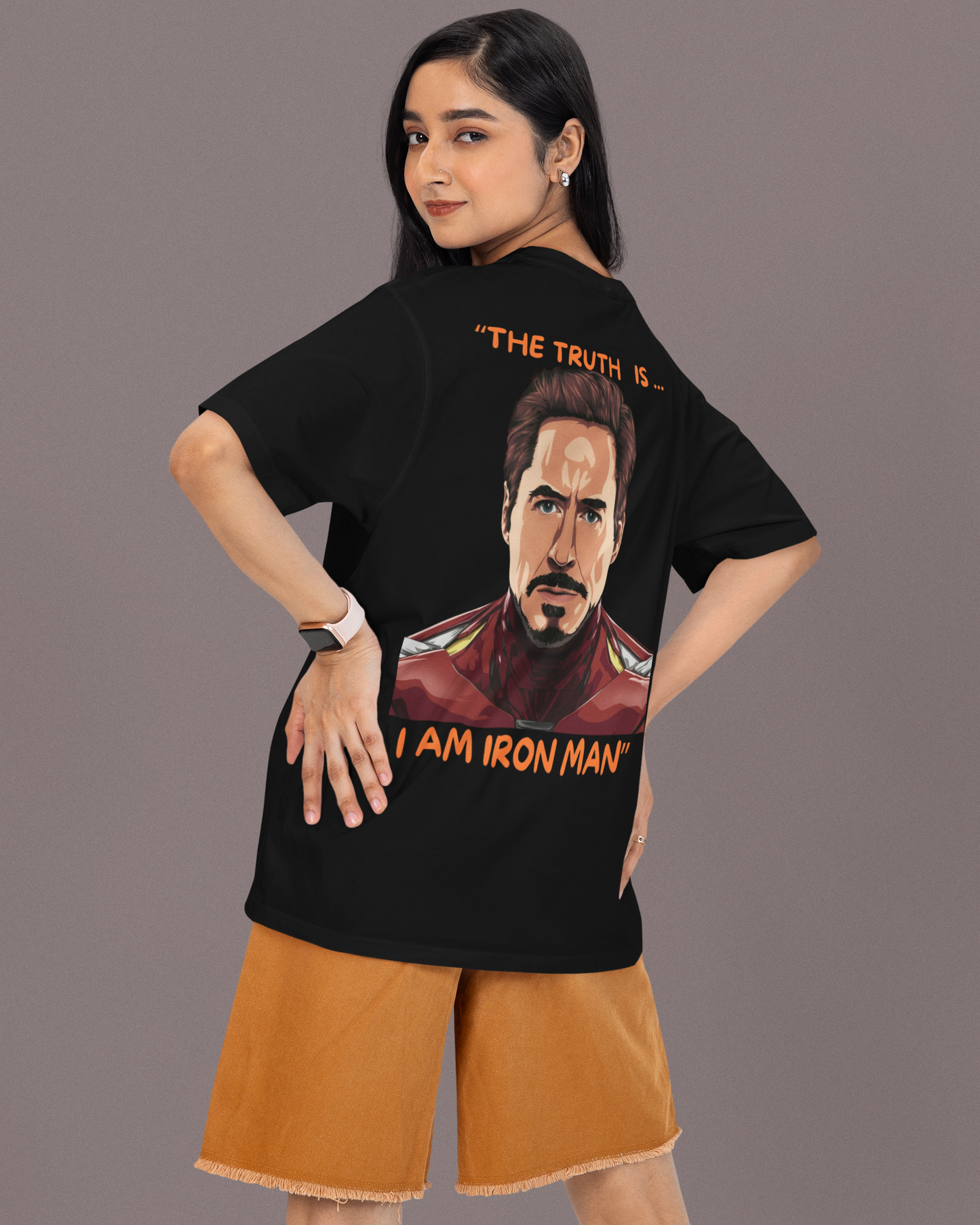 A person modeling an oversized black T-shirt with a graphic print of Iron Man and the text 'I AM IRON MAN' on the front.