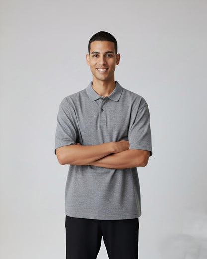 Man wearing a gray polo shirt against a plain background