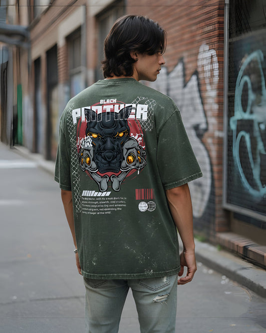 Person wearing a green t-shirt with a Black Panther graphic on the back, standing in an urban setting.