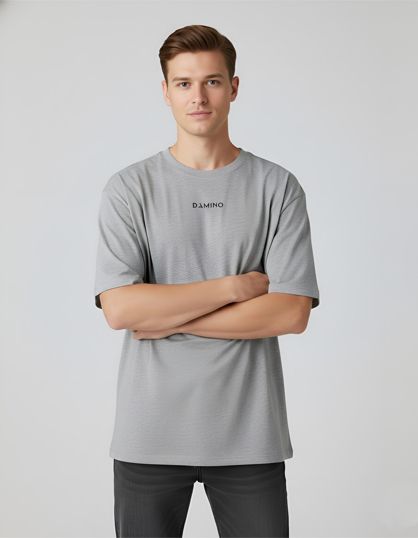 Man wearing a gray t-shirt with a brand logo on a light gray background